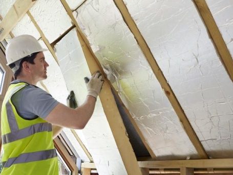 Installer fitting PIR Insulation within ceiling
